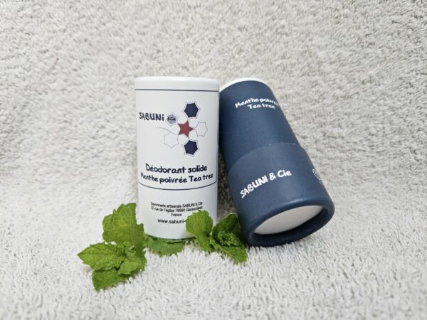 Tube du déodorant (menthe poivrée et tea tree) de Sabuni & Cie, posé sur une serviette, le dessous du tube en carton est visible.