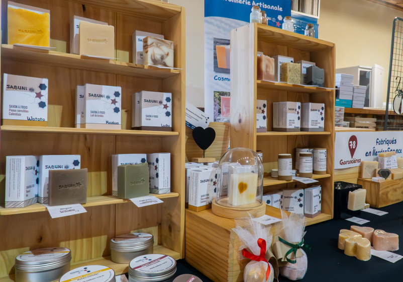 Photo du stand de Sabuni & Cie avec les cosmétiques posés sur des étagères en bois