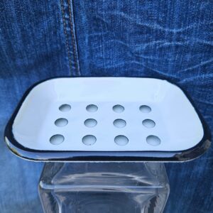 Accessoire zéro déchet de la savonnerie artisanale Sabuni & Cie. Porte-savon en fer émaillé fabriqué en Europe. Porte-savon en fer émaillé sur fond bleu jeans.