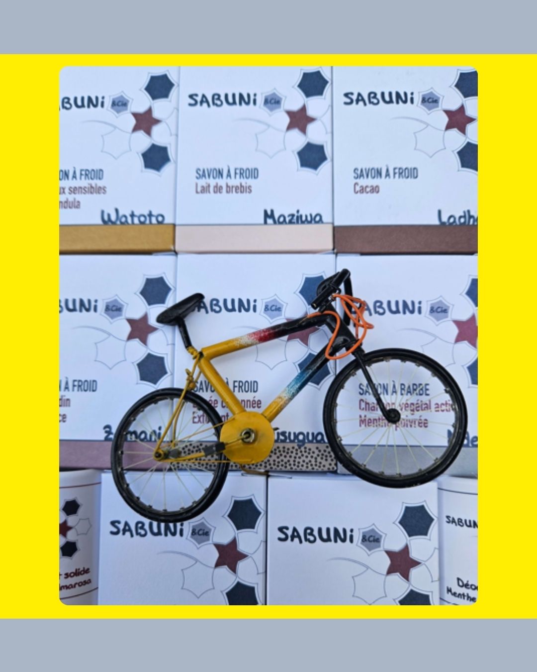 Photo d'un velo devant les articles logotés de la savonnerie artisanale Sabuni & Cie